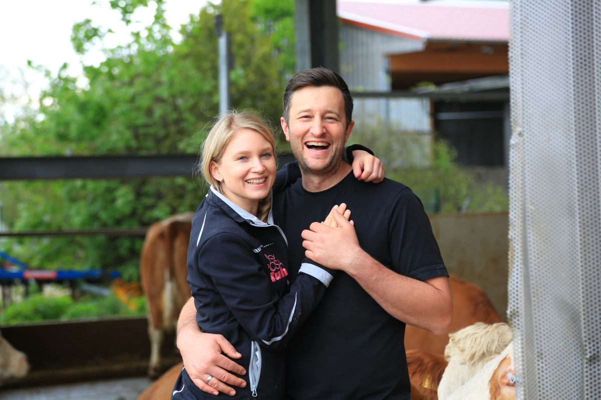 Steffi und Michi Bauer umarmen sich vor dem Kuhstall.