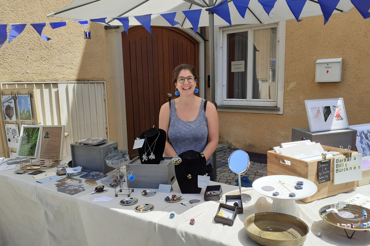 Ein Marktstand mit einer HeimatUnternehmerin zeigt Schmuck, Papeterie und Trauergegenstände