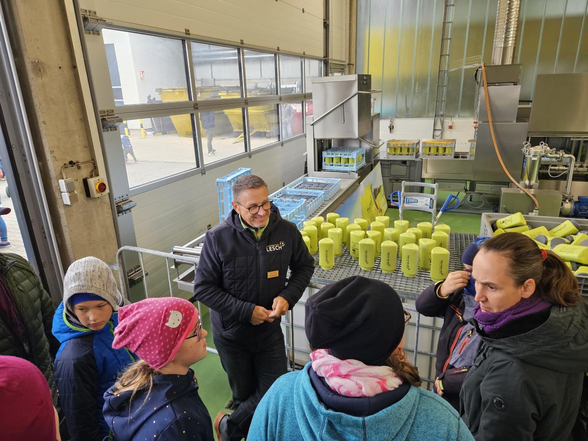 Kinder stehen an einer Verarbeitungsanlage