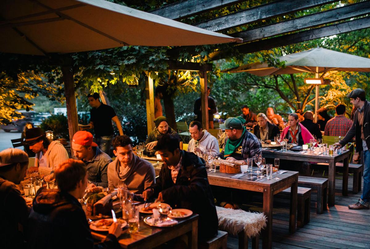 Menschen sitzen nachts  in der Schnitzmühle draußen und essen