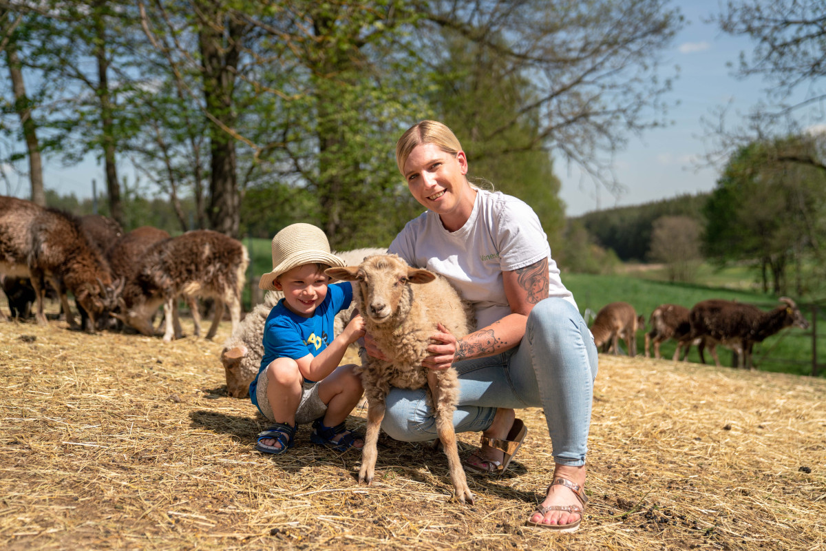 Vanessa und Sohn mit einem Schaf in ihrer Mitte.