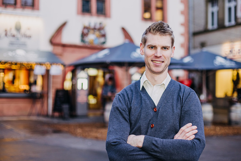 Marcus Beran steht vor seiner Vinothek auf dem Marktplatz