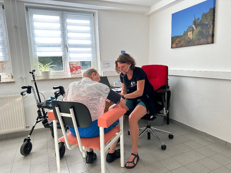 Ein Patient wird von einer weiblichen Person medizinisch versorgt