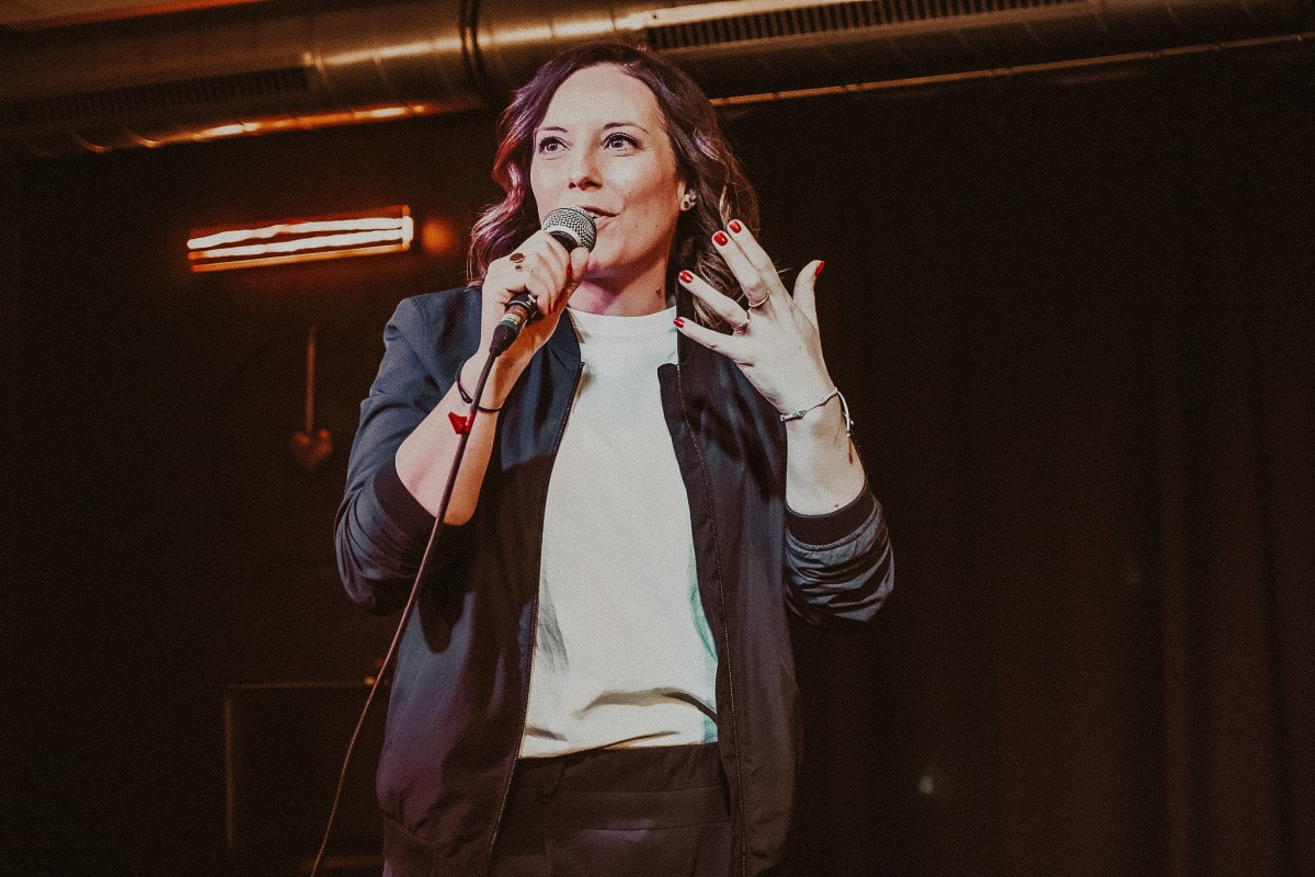 Franziska Glaser auf einer Bühne mit einem Mikrofon in der Hand.