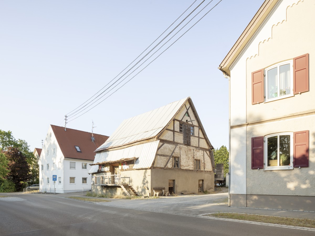 Ein historischer Speicher mit Fachwerk und Mansarddach zwischen zwei schwäbischen Höfen