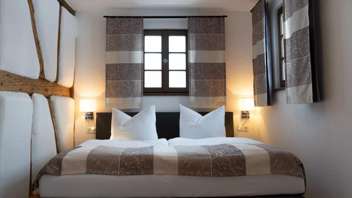 Man sieht ein Fachwerk-Zimmer. Ein ganz besonderer Ort zum Schlafen: Im Mühlenhof träumt man in historischen Mauern.