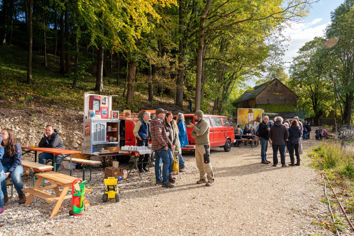 Menschen stehen vor Bierbänken und reden.