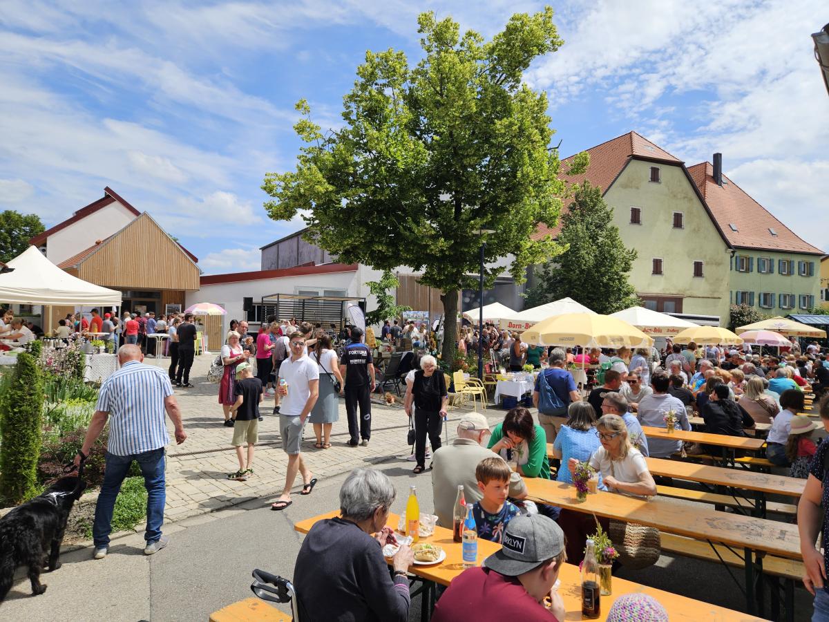 Menschen auf einem Dorfplatz bei einem Fest