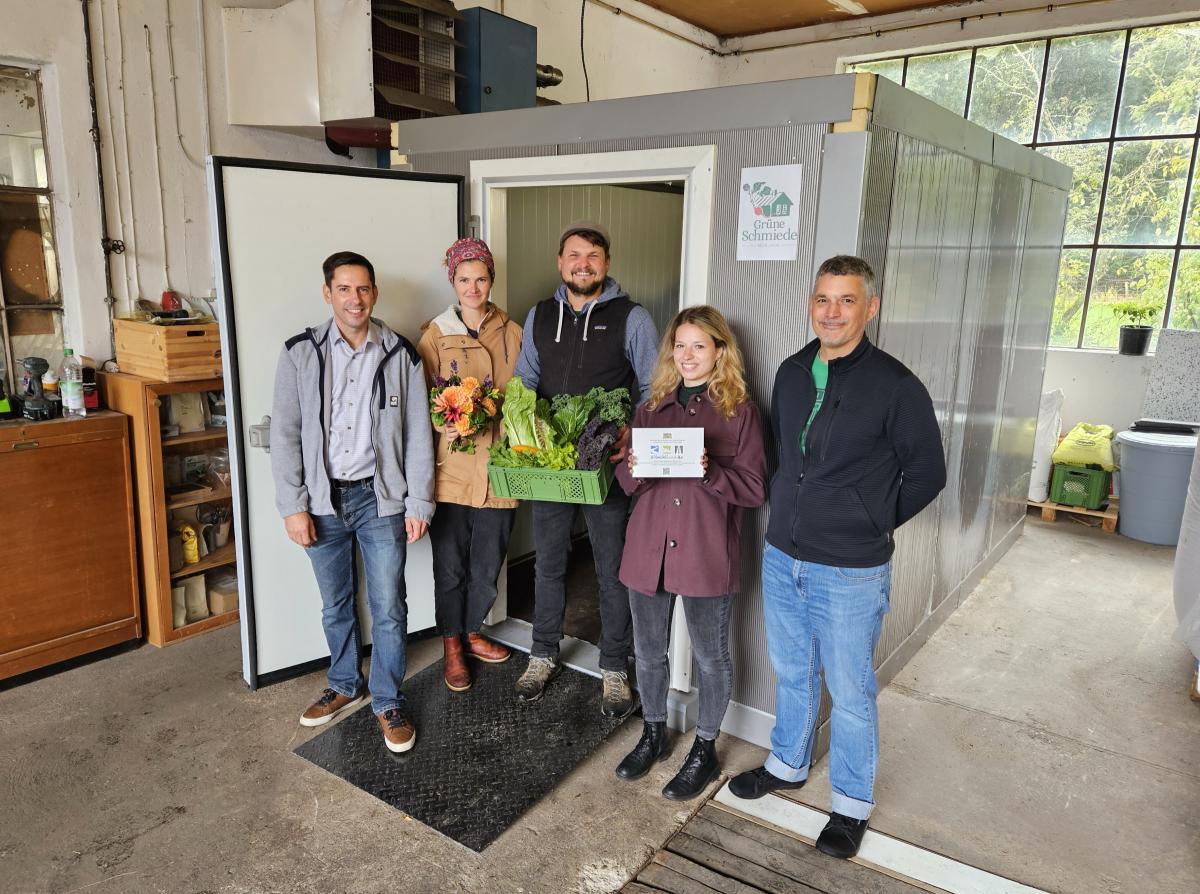 Fünf Menschen stehen vor einer Kühlbox