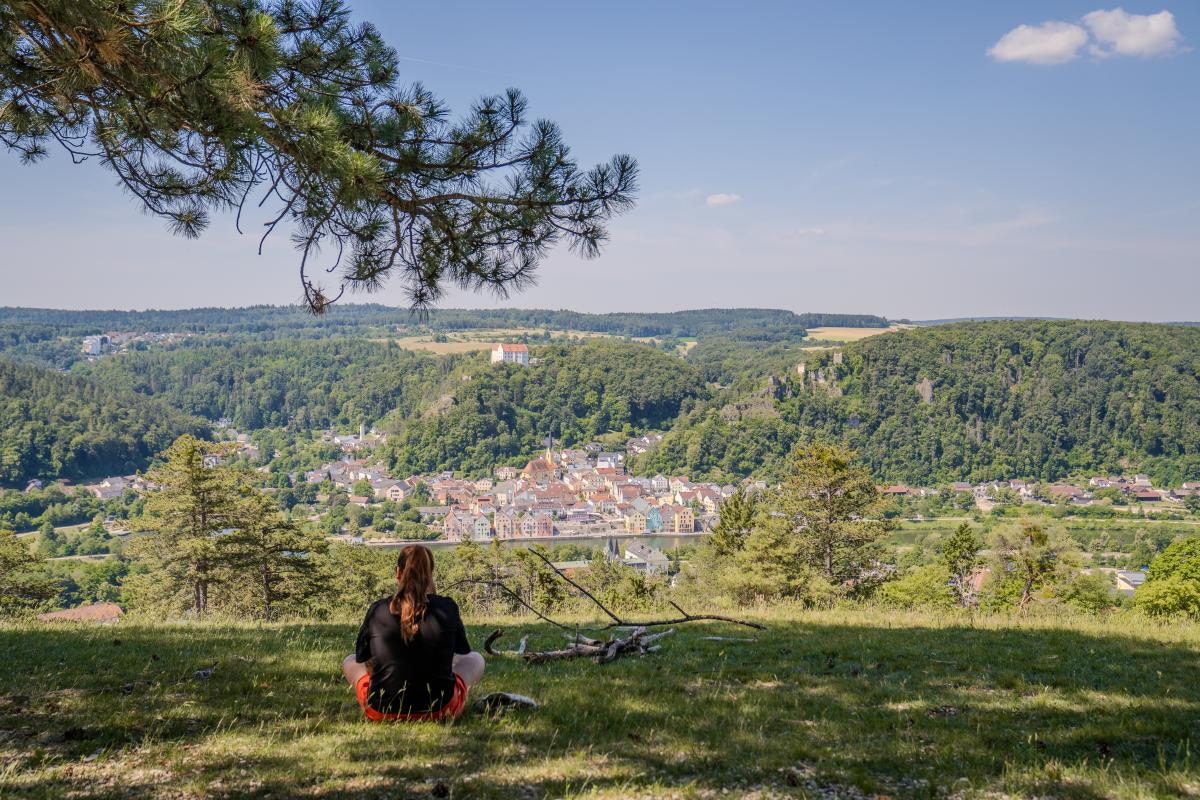 Eine  Frau genießt den Blick ins Tal. Natur erleben und sich wieder mehr als Teil des Ganzen fühlen - dafür sensibilisierte Christof Wegner beim HU Forum 2026.