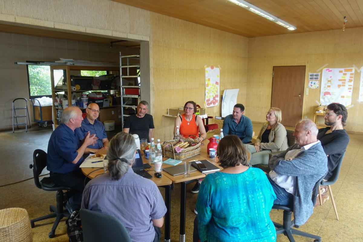 Menschen sitzen an einem Tische zuammen und besprechen das Projekt