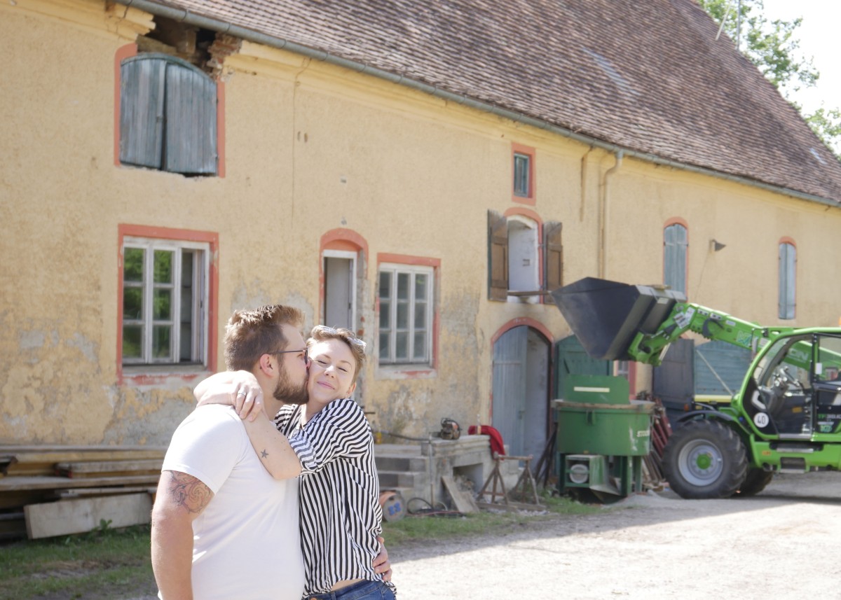 EIn Paar knutscht vor einer Baustelle