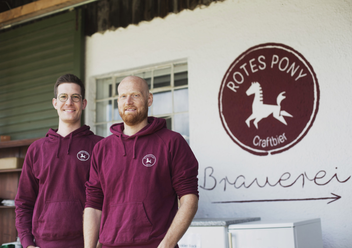 Zwei junge HeimatUnternehmer stehen vor ihrer Brauerei Rotes Pony in Augsburg
