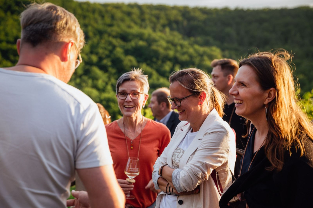 Eine Gruppe Menschen steht im angeregtem Gespräch beieinander