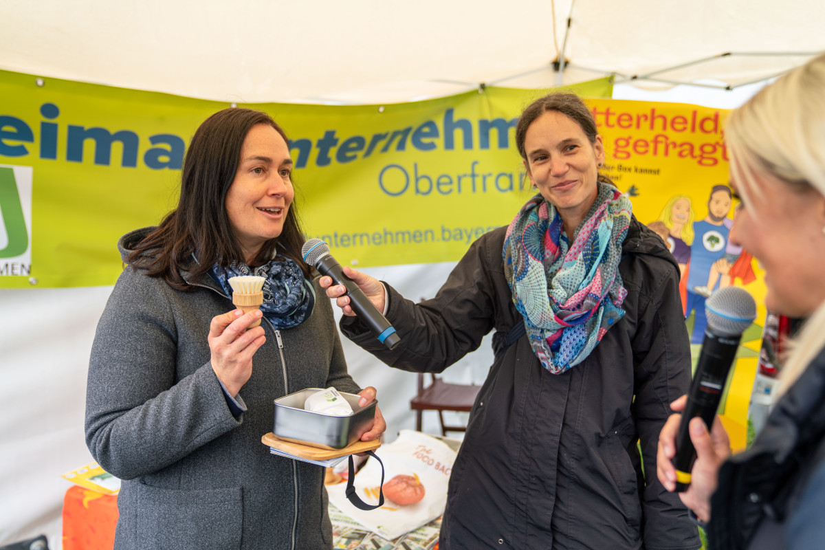 Stefanie Rutz zeigt Gemüsebürste, Anita Nadas hält Mikrophon.
